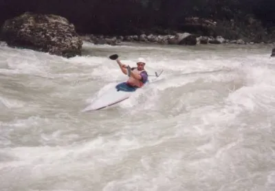 Lionel Tinevez, surf sur la vague en bas du bassin de slalom, avant l'énorme bloc rive gauche